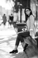 Beautiful model in glasses sit on the fence photo