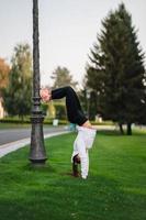 atractiva mujer flaca haciendo un backbend mientras muestra un salto mortal. foto