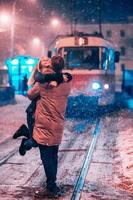 pareja de adultos jóvenes en la línea de tranvía cubierta de nieve foto