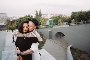 A young, sexy couple of lovers pose for a camera on the streets photo