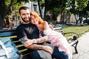 Beautiful dating couple hugging on a bench photo