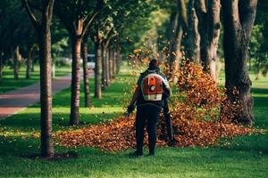 A woman operating a heavy duty leaf blower. photo