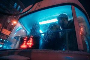 The guy and the girl kiss on the tram behind the misted glass photo