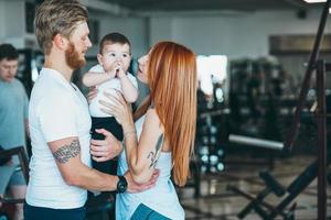 familia joven con niño pequeño en el gimnasio foto