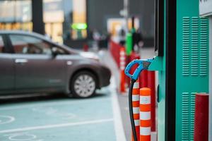 cierre el cable de alimentación del coche eléctrico. estación verde foto