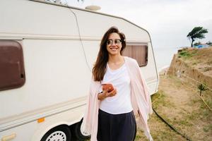 Beautiful, young girl posing on a wild beach sailor at the van photo