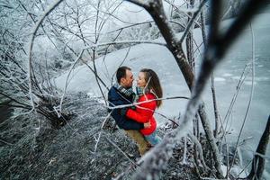 beautiful couple posing near a frozen river photo