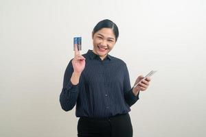 Asian woman using smartphone with hand holding credit card photo