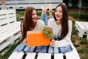 las chicas se acuestan en el banco y se dan regalos foto