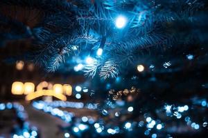 Christmas tree with cones on a city street illuminated with a garland. photo