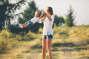 madre e hija en un camino rural foto