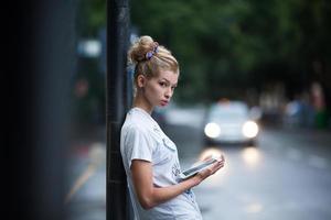 lindas chicas con tableta en una estación de autobuses foto