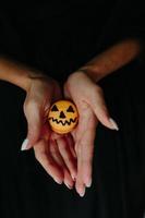mujer sosteniendo una galleta para halloween foto