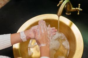 Close up photo of woman washes her hands with soap and water.