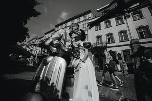 bride and groom on vintage motor scooter photo