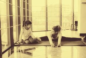 Mother and daughter makeing yoga in the gym photo