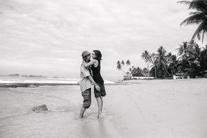 a guy and a girl are kissing on a beach photo