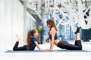 Young adult mom and little daughter together on aerobics photo