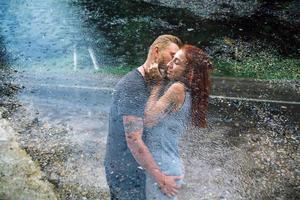 beautiful couple hugging in the rain photo