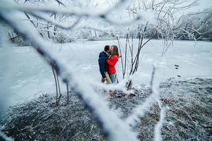 beautiful couple posing near a frozen river photo