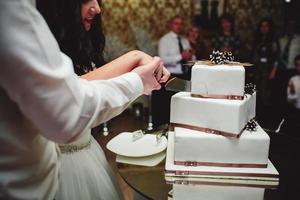 la novia y el novio cortan el pastel foto