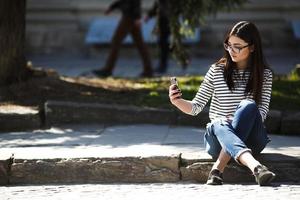 modelo en medio de la ciudad con telefono foto