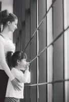 Two girls of different ages stare in a window in the gym photo