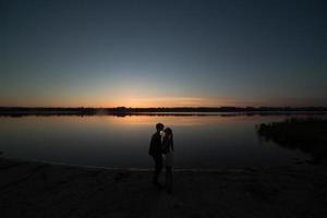 Couple in sunrise on the beach photo