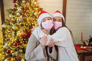 Two girls in protective masks looking at the camera and waving photo