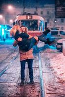 pareja de adultos jóvenes en la línea de tranvía cubierta de nieve foto