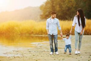 Young family walking at the beach photo