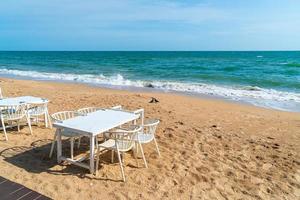 dinning table and chair on beach with sea background photo