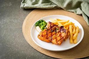 grilled chicken steak with potato chips or french fries photo
