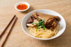 dried noodles with braised duck in white bowl photo