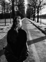 Portrait of a brunette girl having fun in a park in the rays of the bright sun. photo