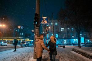 adulto joven pareja caminando sobre la acera cubierta de nieve foto