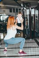 joven madre con su hijo pequeño en el gimnasio foto