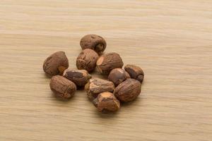 Small nutmeg on wooden background photo