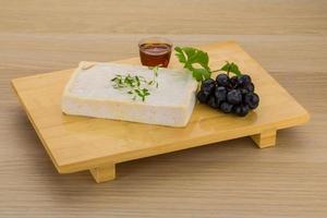 Brie cheese on wooden board and wooden background photo