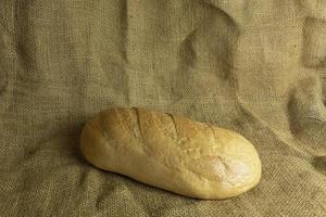 Fresh handmade bread on sackcloth background photo