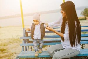 Mother and young son together on a bench photo