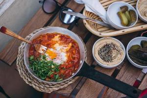 Shakshuka, Fried Eggs in Tomato Sauce on the Table photo