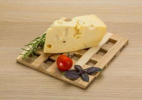 Maasdam cheese on wooden board and wooden background photo