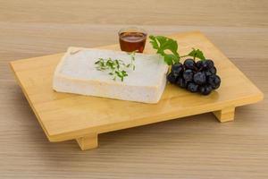 Brie cheese on wooden board and wooden background photo