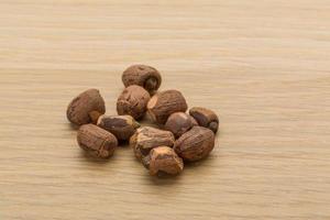 Small nutmeg on wooden background photo