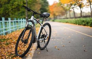 White bicycle standing in park. Morning fitness, loneliness. photo