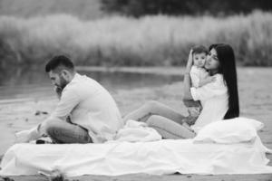 Happy young family relaxing together on the lake photo