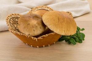 Boletus mushroom in a basket on wooden background photo