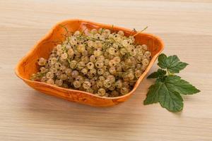 White currant in a bowl on wooden background photo