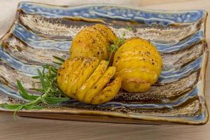 Baked potato on the plate and wooden background photo